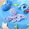 This is a closeup shot of cute octopus on top of our under the sea theme cake we have a small whale also at the background