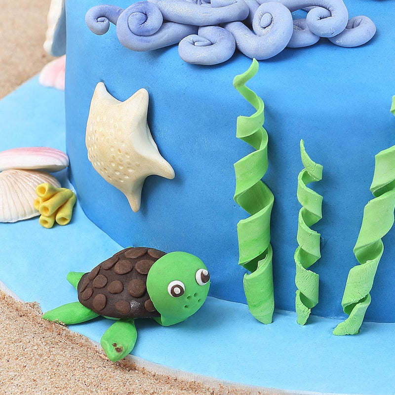 A cute little turtle on sides of this sea theme cake, we also have a star fish and sea weeds figurines on this under the sea cake of create the overall experience of sea theme cake