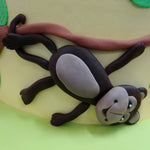 Monkey hanging on the side of our Jungle theme cake 
