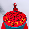 Zoomed view of spiderman cake design with a little spiderman sitting on top of the cake