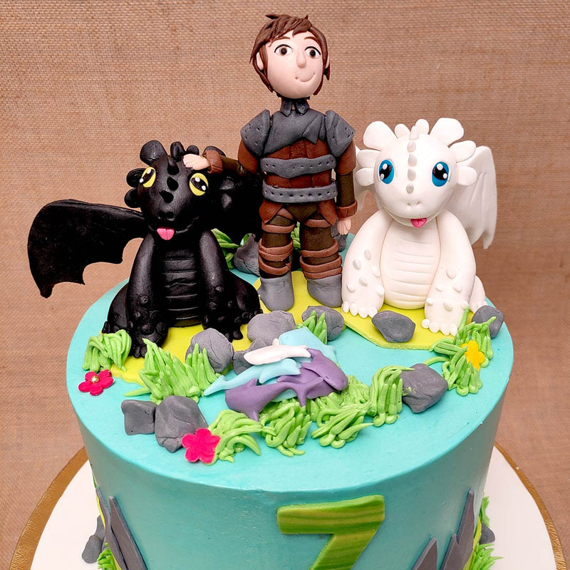 Zoomed view of toothless and light-fury cake along with their human cartoon friend hiccup. This how to train your dragon cake will surely be hit on your kids birthday