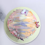 Top view of Ombre cake with three different color shades mixed into each other and edible butterflies and pearls thats adds more beauty to this Colorful cake 