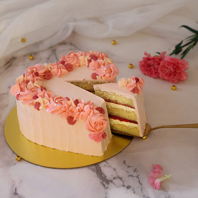 Here's a heart shape birthday cake that is designed in size and presentation to resemble a heart-shaped gift box. Velvet-like, pale-pink buttercream is what the base of this heart shape cake design is frosted with and showcases vertical partitions textured down the sides.