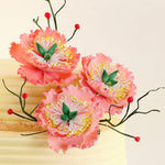 This floral anniversary cake combines the best of both by adoring each layer of the 2 tier floral cake with edible flowers made from sugar and buttercream, crafted with care by hand.