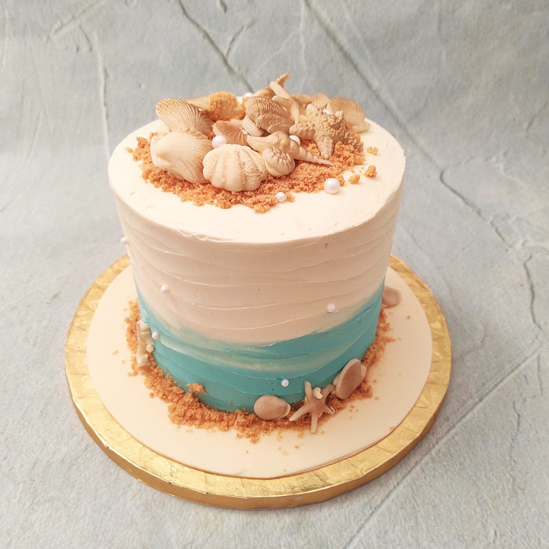 Let’s go on a magical adventure to the seaside, with a beach cake that is so nostalgia-inducing, you’ll practically be able to smell the sea salt. For all the beach babies out there, you can be rest a‘shore’d that this beach birthday cake will make sure your celebrations are a spe-shell one!