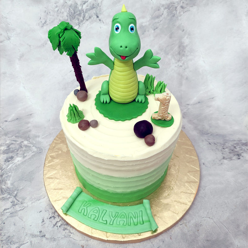 This dino cake for boys and girls is a tropical treat that is set on an island. The green to cream gradient that coats the base of this dinosaur cake for kids is going to just melt in your mouth like a popsicle on a hot summer's day.