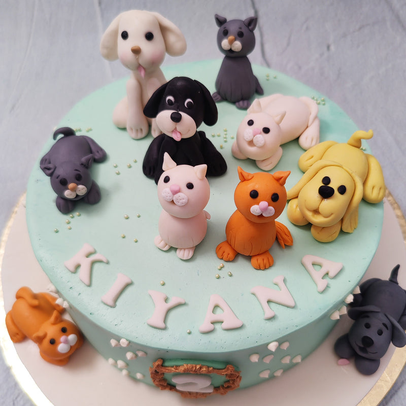 Feline and furry figurines of a variety of dog and cat breeds have been recreated and placed all over this dog and cat birthday cake for kids in colours of ginger, yellow, grey, white and black. 