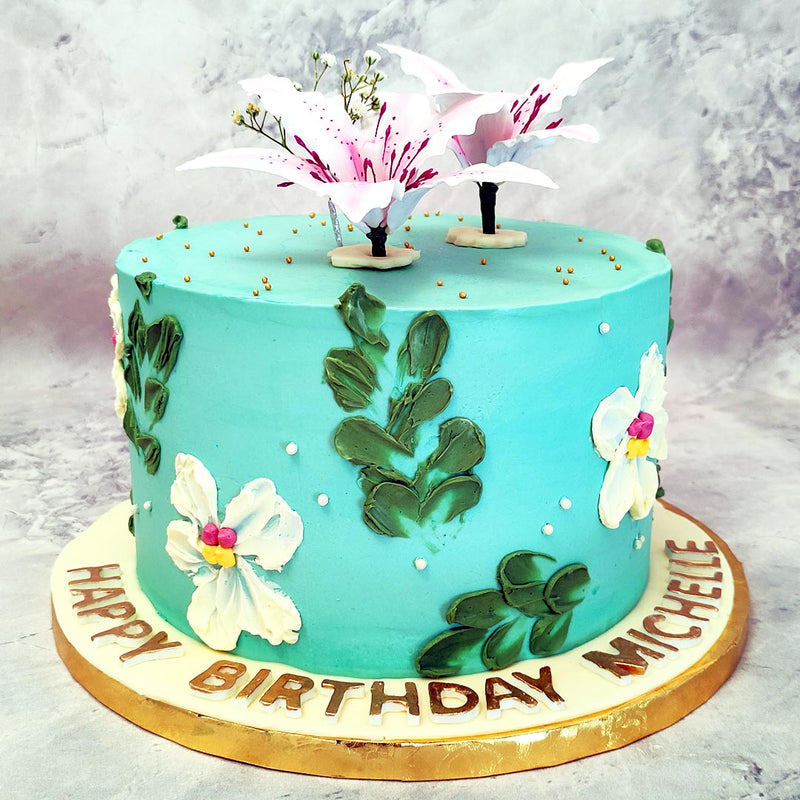 the show-stopper is the lily cake topper: two very realistic and very edible lily flowers have been created and displayed on top of this edible lily floral cake. 
