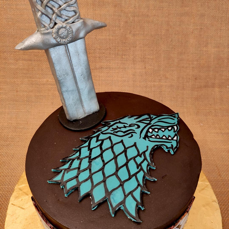 the House of Stark symbol of a wolf is proudly displayed on top of this winter is coming cake for him. 