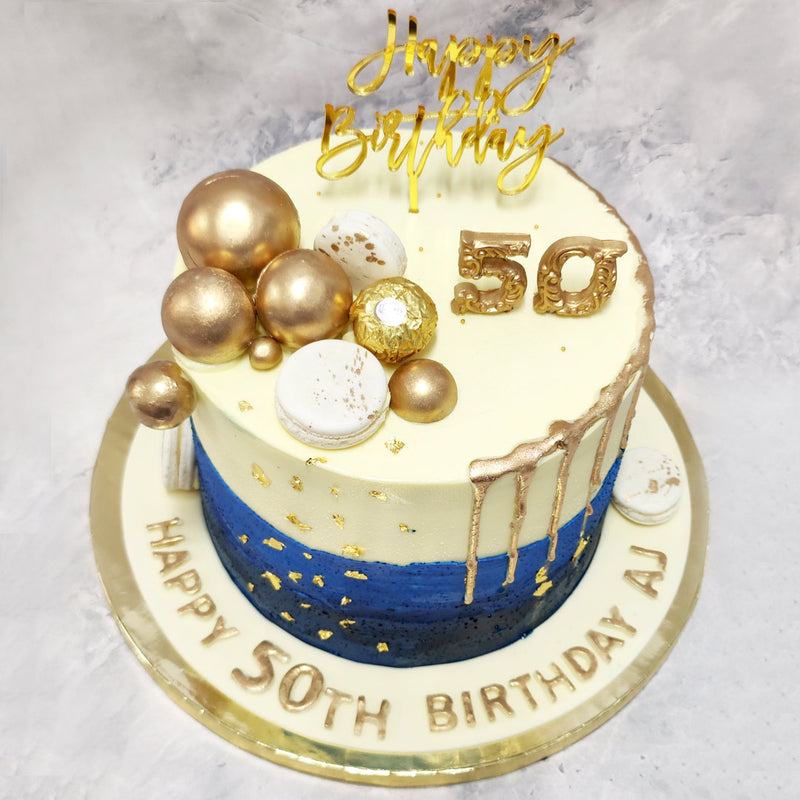 One half of this blue ombre cake utilizes the golden drip cake design and the other side is decorated with white macaroons, edible gold baubles and a delicious Ferrero Rocher chocolate.