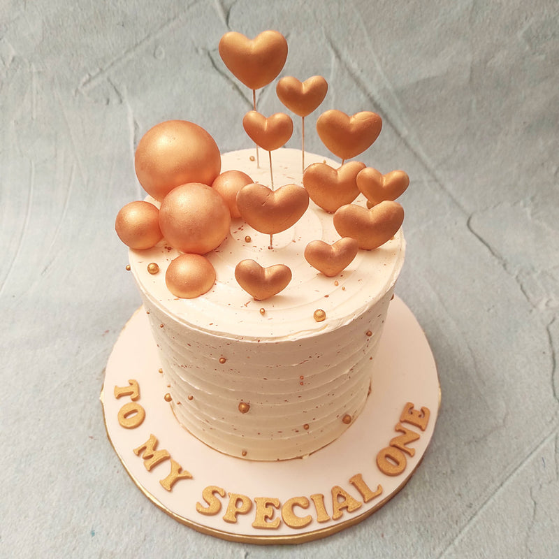  The base of this heart theme cake is coated in delicious, white buttercream, laid on in a concentric and textured style that adds dimension to this heart themed cake birthday cake for kids.