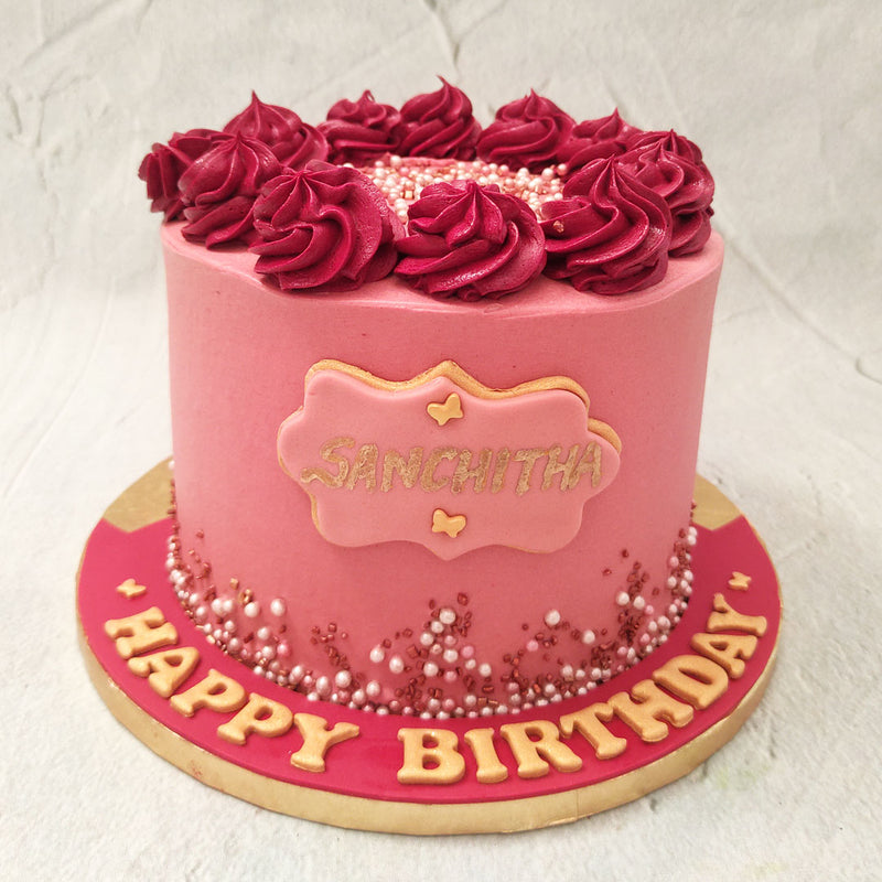 Beautiful, rosey swirls form a wreath around the top of this birthday cake for him / birthday cake for her. Adding even more dimension and drool-worthy elements to this maroon cake.