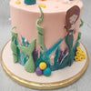 This mermaid tail cake buttercream dream comes with a pink base and ornamented with all the treasures you can find under the sea. Abstract paint brush strokes coat the bottom of this mermaid tail birthday cake for kids. 