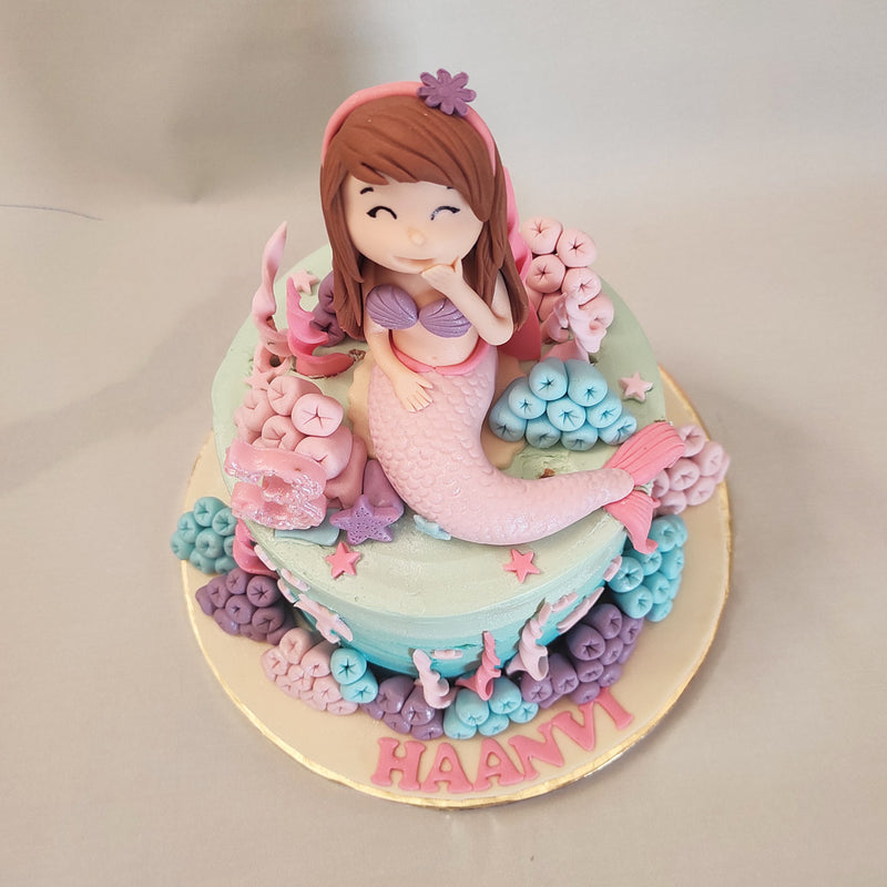 The base of this mermaid birthday cake for kids features an ombre-style gradient of blue used and layered like waves of the sea to properly do justice to the aquatic theme of this design.