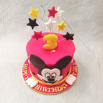 To begin with, pink, white, yellow and black, colourful, 3D stars embellish the top of this Mickey Mouse cake like sparklers or fireworks one may find at Disneyland. The design of this Mickey Mouse theme cake truly paints the picture of a youthful celebration, which can never be fully complete without something Disney.