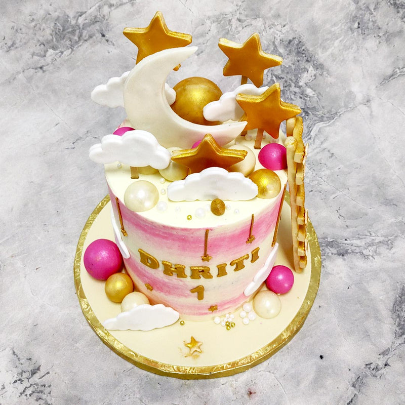 The base of this moon and stars birthday cake for kids used a pink and white ombre colour scheme on the tall base which acts as a background for the birthday girls' name to be displayed in a textured, gold 2D format.