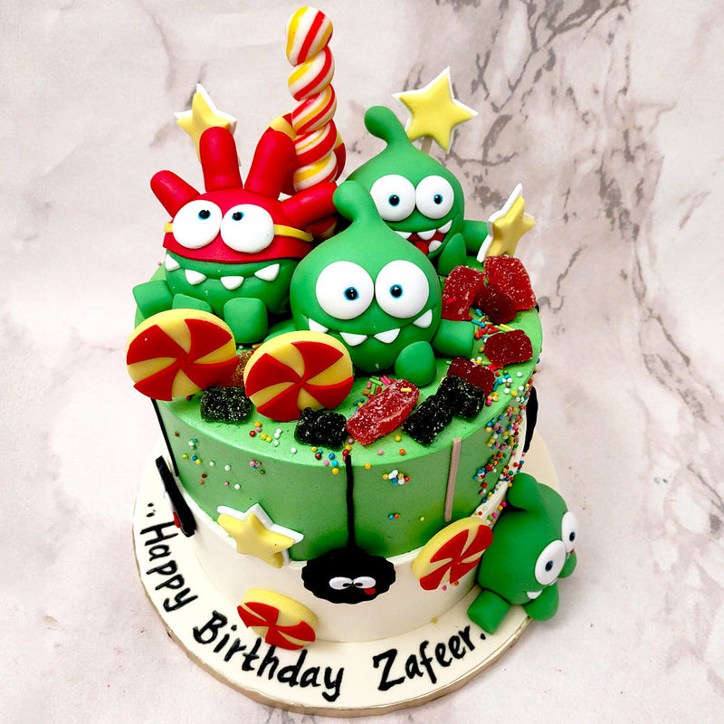   This Om Nom Cut The Rope cake is inspired by the physics-based video game series where you solve a puzzle to feed candy to the little green creature known as Om Nom. 