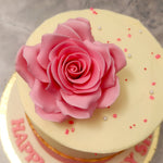 The pink and white colour theme of this pink rose cake in itself represents a certain duality. The pink, which symbolises affection, romance and kindness is both contrasted and highlighted by the symbolically innocent and fresh other colour: white.