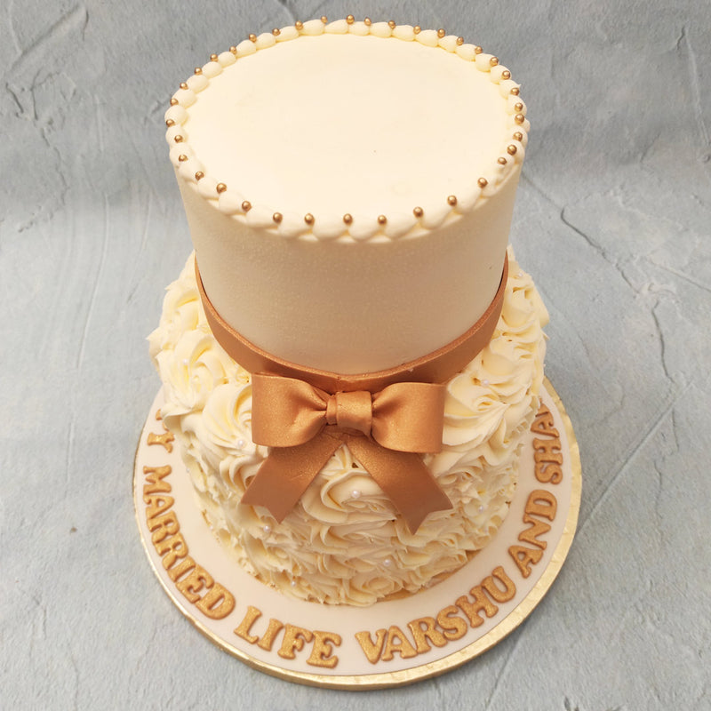 This rosette two tier cake features a clean, white finish as the top tier with the entire bottom tier covered in piped buttercream roses, swirling in drool-worthy spirals that will just melt in your mouth. 