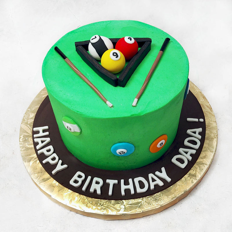 Like a pool table, the base of this billiard cake comes in a grassy shade of green, textured like the felt fabric used in real life! Colourful, 2D pool balls embellish the sides of this billiard themed cake design and the top is decorated with the cues, the triangle rack and some more rounded pool balls, including the white cue ball, all created to look realistic, artistic and life-like.