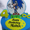 The base of this kids birthday cake is created to replicate the outdoorsy terrain in the game and is coloured blue like the super sonic sky. Some grass and trees are piped on with green buttercream to give it more of an authentic design and taste and a singular white cloud made of fondant can be seen floating on by the circumference of this cartoon cake. 