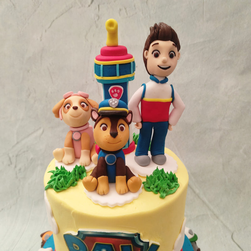 This Paw Patrol theme cake is meant to take kids on an adventure through Adventure Bay, the Paw Patrol community. The bottom tier of this Paw Patrol birthday cake for kids comes in an elegant shade of blue embellished with white bones all over. 