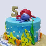 Smiling octopus on top of Sea theme cake and a 5th year birthday cake topper