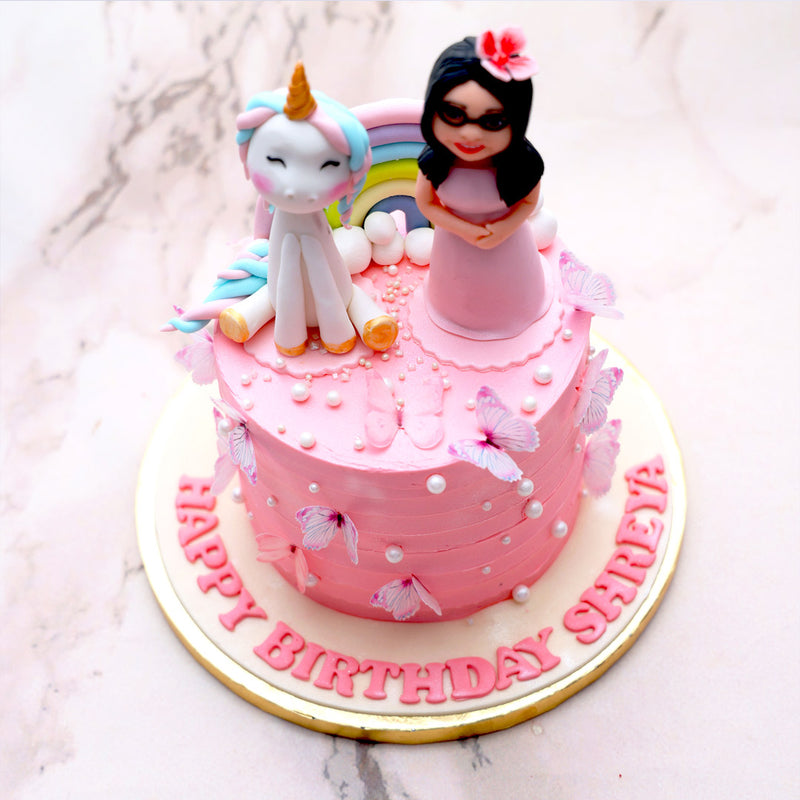 The base of this girl with unicorn cake design is in a shade of pretty, princess pink, frosted with thick and silky buttercream worthy of being served to royalty. The buttercream is textured, layered and embellished with lustrous white pearls all over in different shapes and sizes. 