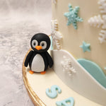 With the friendly baby penguins near the bottom tier and the happy little snowman with his blue scarf and hat on top, this would be an adorable design for a birthday cake for kids.