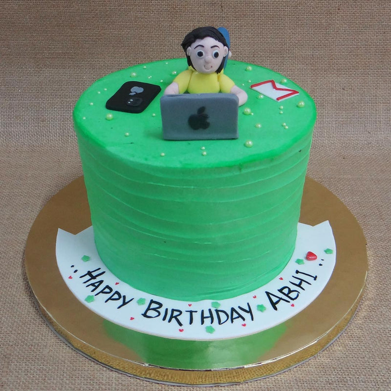 A man made of cake represents the man of this work from home theme cake for him. This man on this birthday cake for workaholic husband, sits in front of his apple laptop hustling hard while a gmail icon seems to have fallen out of his laptop. An apple iphone has been recreated in an edible miniature version and neatly placed next to the man who works endlessly.